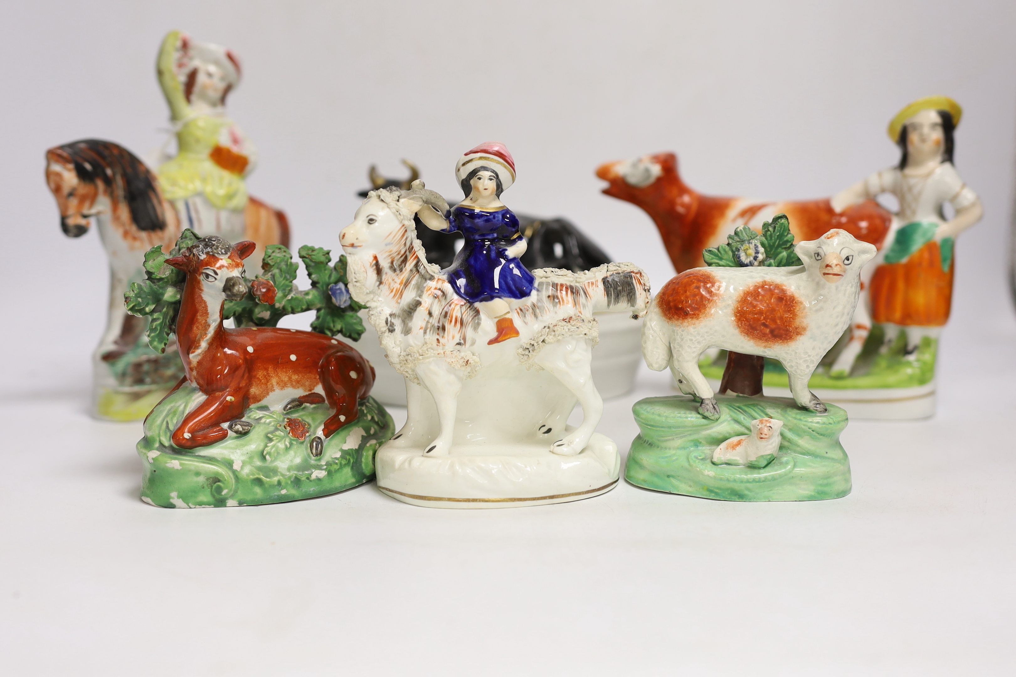 A Victorian Staffordshire cow tureen and cover, and five other Staffordshire figures, largest 18cm wide